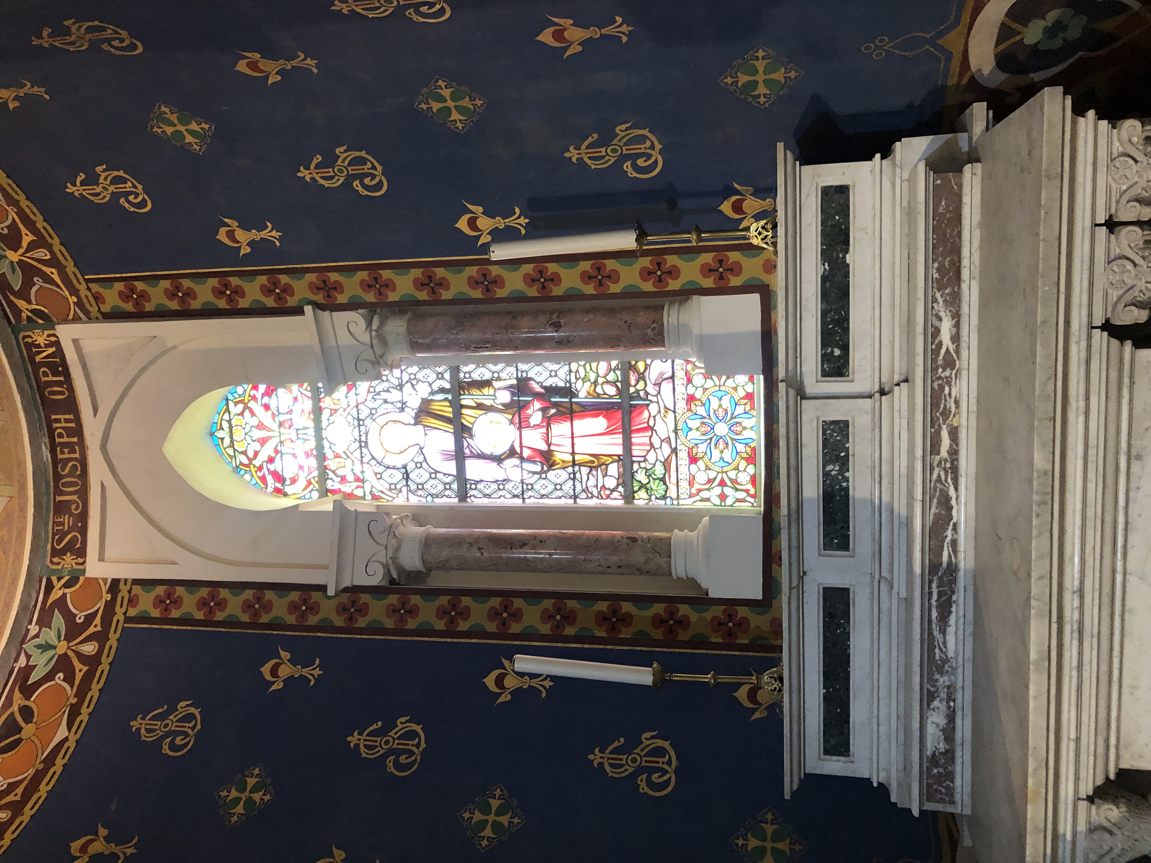 St. Joseph side altar with a stained-glass window depicting Saint Joseph and the Child Jesus inside the Basilica of Saint Augustine in Annaba, Algeria.